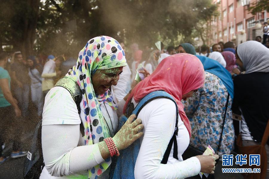 10月16日，在埃及首都開羅，兩名女青年在“彩色跑”活動(dòng)中躲避人們拋撒的彩色粉末。