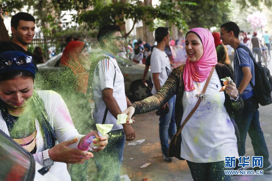 10月16日，在埃及首都開羅，一名女青年在“彩色跑”活動(dòng)中拋撒彩色粉末。