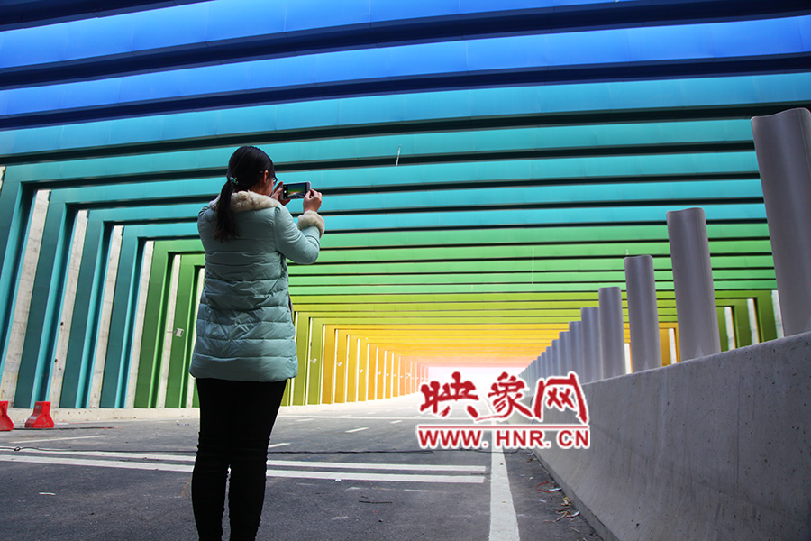 一女孩拿出手機(jī)拍照。