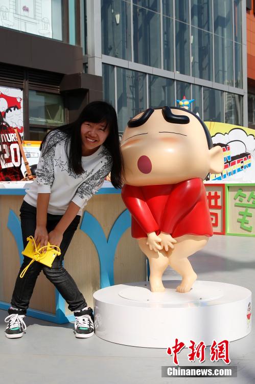4月22日，游客與蠟筆小新合影?！跋灩P小新25周年紀(jì)念特展”日前在北京開展，吸引了不少市民游客。