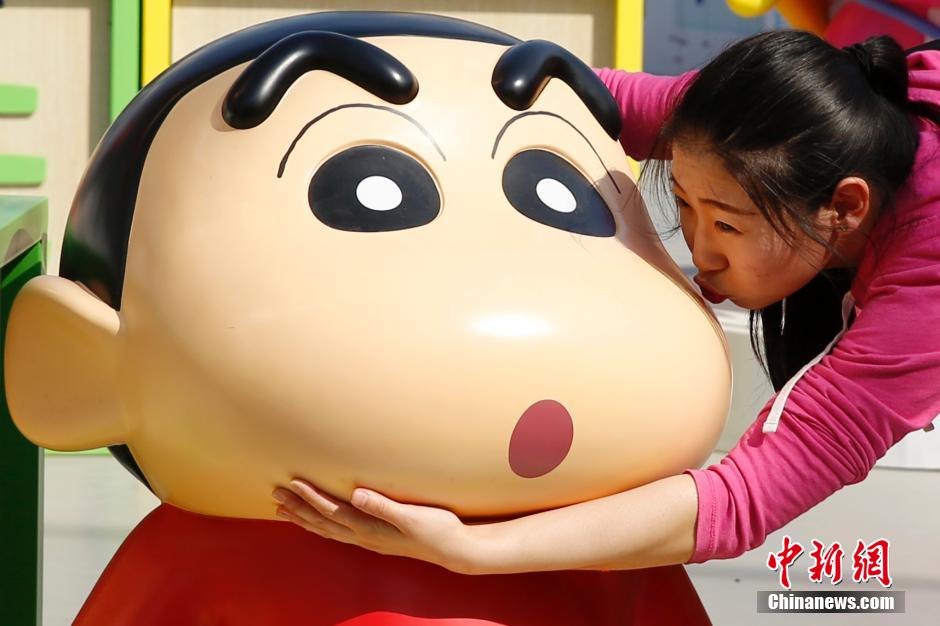 4月22日，游客與蠟筆小新合影?！跋灩P小新25周年紀(jì)念特展”日前在北京開展，吸引了不少市民游客。