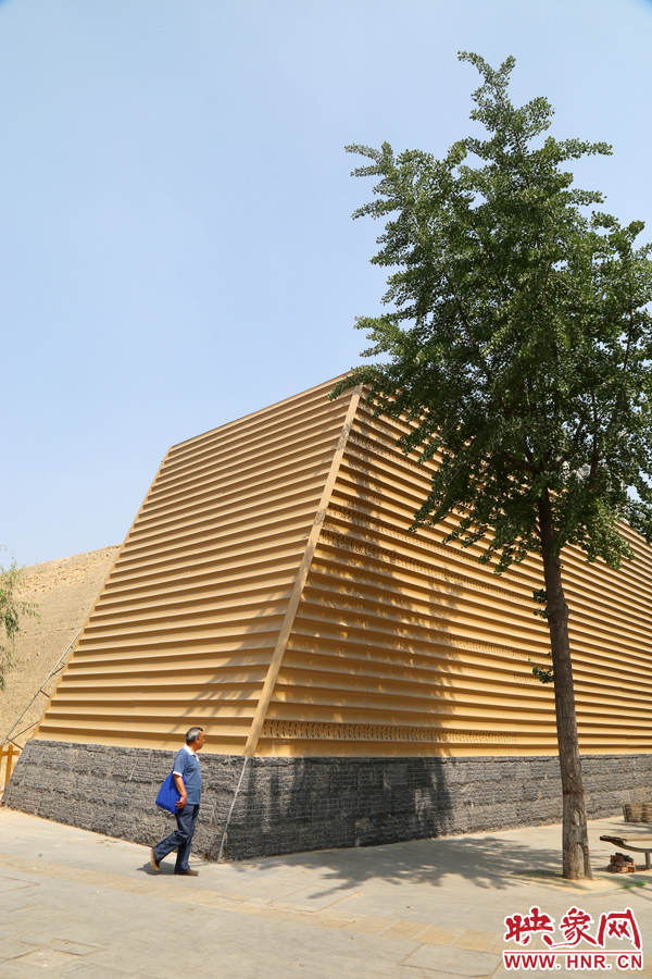 一名路人從“土豪金”保護(hù)殼前經(jīng)過。