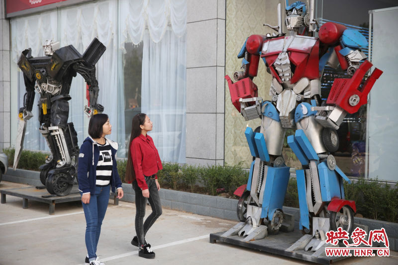 10月14日，市民在參觀河南省平頂山市寶豐縣一家企業(yè)門前的“變形金剛”。