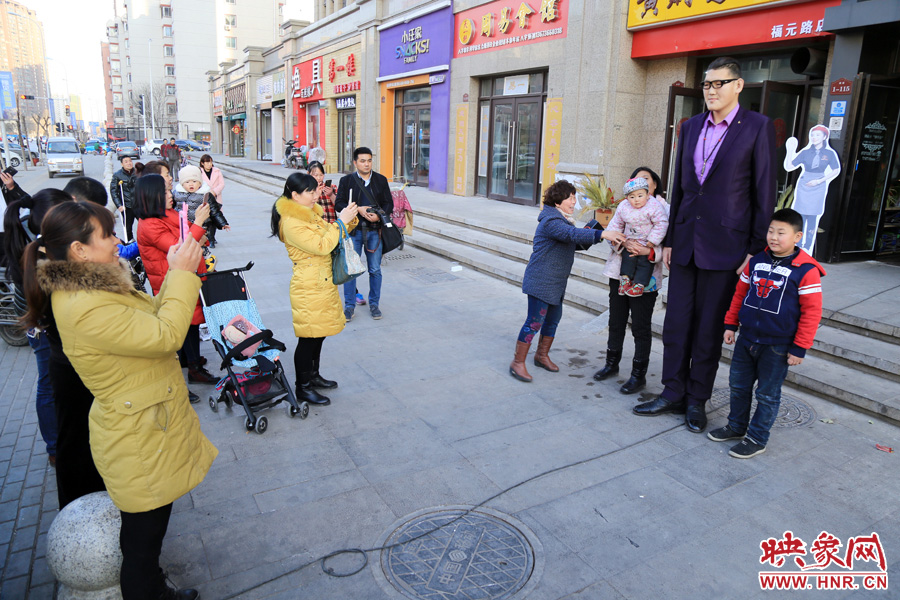 過(guò)路市民爭(zhēng)相與“巨人”合影。