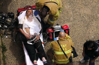 2日，救援人員在美國紐約地鐵事故車輛內(nèi)緊急疏散一名受傷乘客。圖/CFP