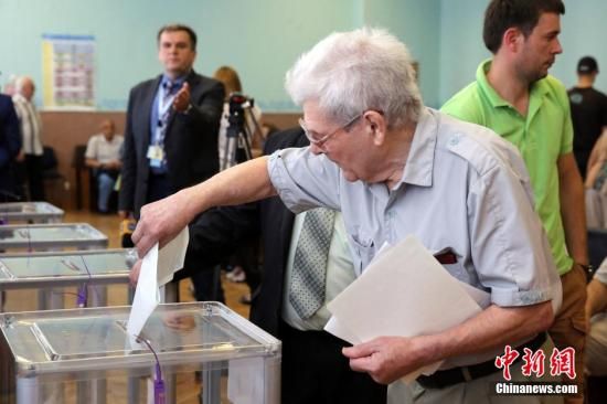 　5月25日，一名烏克蘭選民把填好的選票投入選票箱。