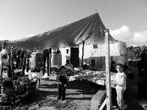 黎巴嫩一敘利亞難民營，難民支起攤鋪賣衣服掙錢。