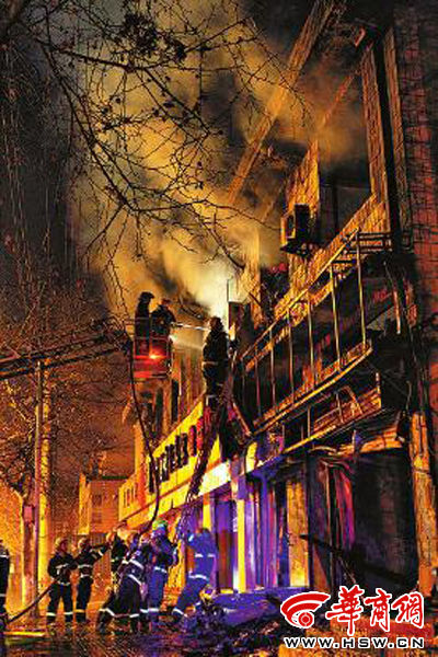 昨日22時(shí)10分，西安市豐慶路南小巷南口，消防官兵架梯子登上二樓施救 本組圖片由本報(bào)記者 閆文青 攝