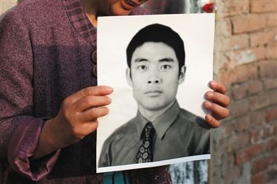 5月19日，朝陽(yáng)北路，母親捧著張東文的遺像。新京報(bào)記者 侯少卿 攝