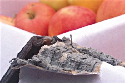 8月29日，新發(fā)地市場，一箱用“加重紙箱”包裝的蘋果正待售，紙箱夾層內(nèi)灰黑色的增重填充物清晰可見