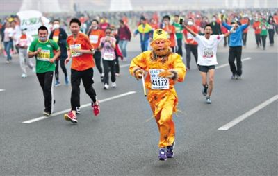 長(zhǎng)安街，一名打扮成孫悟空的參賽者在北馬隊(duì)伍里飛奔。 本版攝影/新京報(bào)記者 吳江 李飛 王嘉寧 吳江