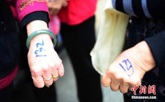 圖為10月28日，在江西九江市一家羊絨皮草服裝服飾博覽會(huì)現(xiàn)場，老人們正在頂著寒風(fēng)排隊(duì)等待領(lǐng)取10元代金劵。