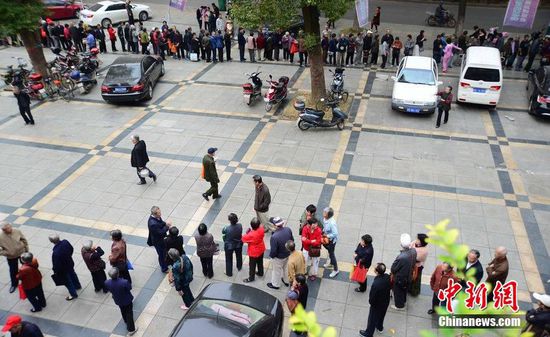 圖為10月28日，在江西九江市一家羊絨皮草服裝服飾博覽會(huì)現(xiàn)場，老人們正在頂著寒風(fēng)排隊(duì)等待領(lǐng)取10元代金劵。
