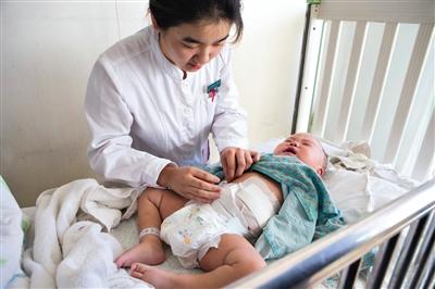 昨日，北京兒童醫(yī)院，護(hù)士為即將出院的被扎鋼針女嬰檢查傷口恢復(fù)情況。記者 高瑋 攝