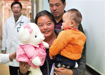 昨日上午，被扎針女嬰的母親抱著孩子和醫(yī)護(hù)人員送的玩偶準(zhǔn)備出院，院方稱孩子術(shù)后恢復(fù)良好。記者 高瑋 攝