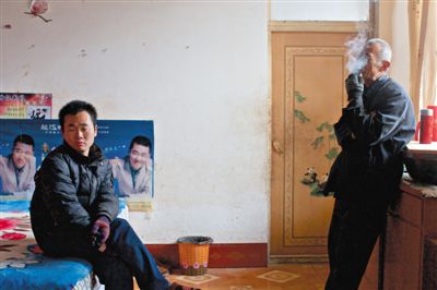 父親抽煙，兒子不語。逃跑的越南新娘，給袁迎賓父子帶來的是失落。新京報記者 周崗峰 攝