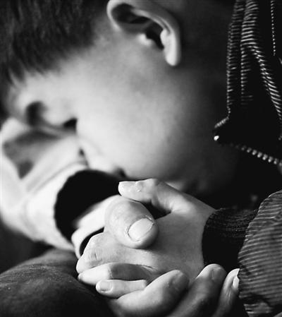 10歲小兒子緊緊握著哥哥的手。資料圖片