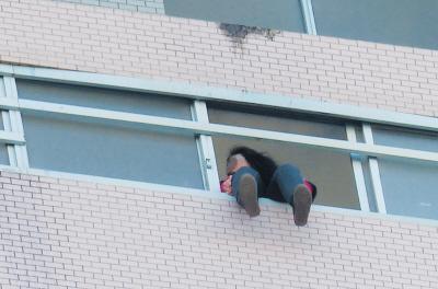 28樓的窗臺上坐著一名女子，其兩條腿耷拉在室外，不停地擺動。