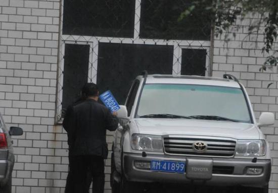 程父與程的“司機(jī)”在居住小區(qū)內(nèi)將黑AB0040車牌更換為黑M41899車牌，倆車牌號(hào)均為空號(hào)