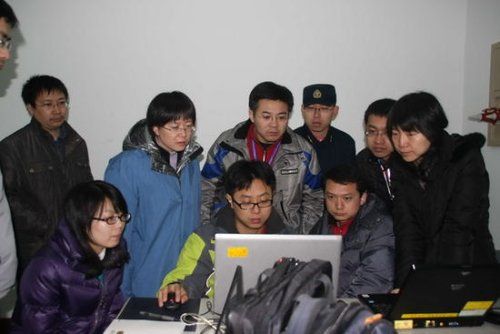 　資料圖：周紅麗（左三）和試驗隊員判讀試驗數(shù)據(jù)。