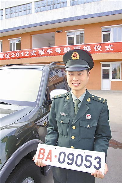 駐京某部長途汽車隊中士王志濤領(lǐng)到新式軍車號牌。