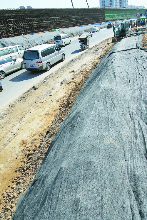 豐樂路與北三環(huán)交叉口，修路的土被歸置得整整齊齊，并用黑網(wǎng)覆蓋，既保暢通又避免了揚(yáng)塵。
