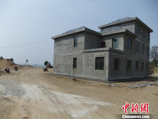 鴨河水庫(kù)庫(kù)區(qū)邊的新建別墅，一面墻上寫著“拆”，另一邊在加緊施工。吳揚(yáng)　攝