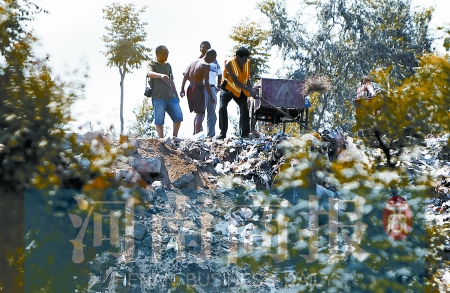 有人正在傾倒建筑垃圾，不遠處就是村民的水井